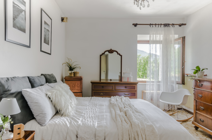 Stanza accogliente luminosa vintage con letto bianco in montagna home staging