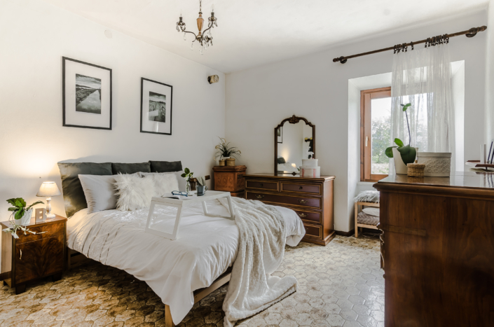 Stanza accogliente luminosa vintage con letto bianco in montagna home staging