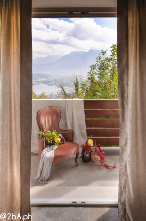 lifestyle poltroncina rossa su terrazza vista lego di caldonazzo fotografia emozionale