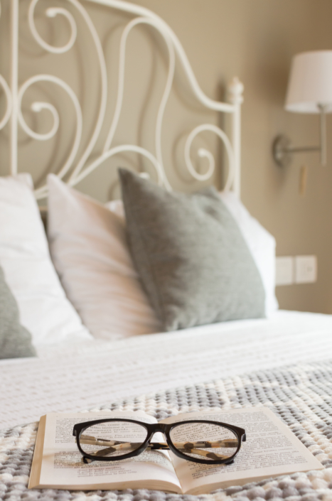 letto romantico con libro e occhiali home staging